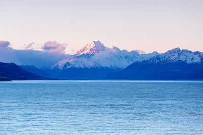 Scenic view of sea and snowcapped mountains against sky