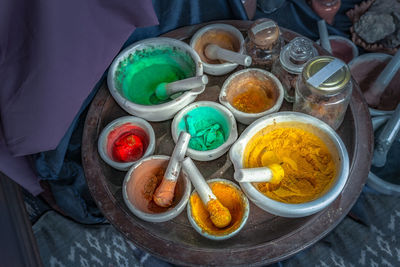 High angle view of powder paints in mortar and pestles on table