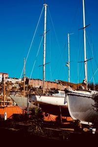 View of marina at harbor against clear blue sky