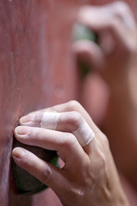 Close up of hand holding on to handhold at indoor climbing gym