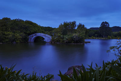 Arch bridge over river against sky