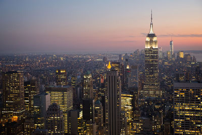 Aerial view of city lit up at sunset