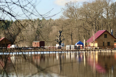 Houses by lake against sky