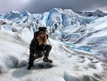 Portrait of woman crouching on glacier 