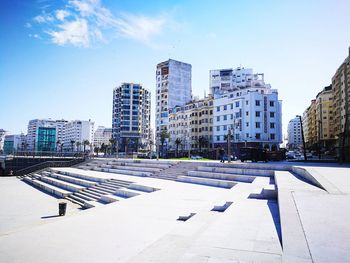 Modern buildings in city against blue sky