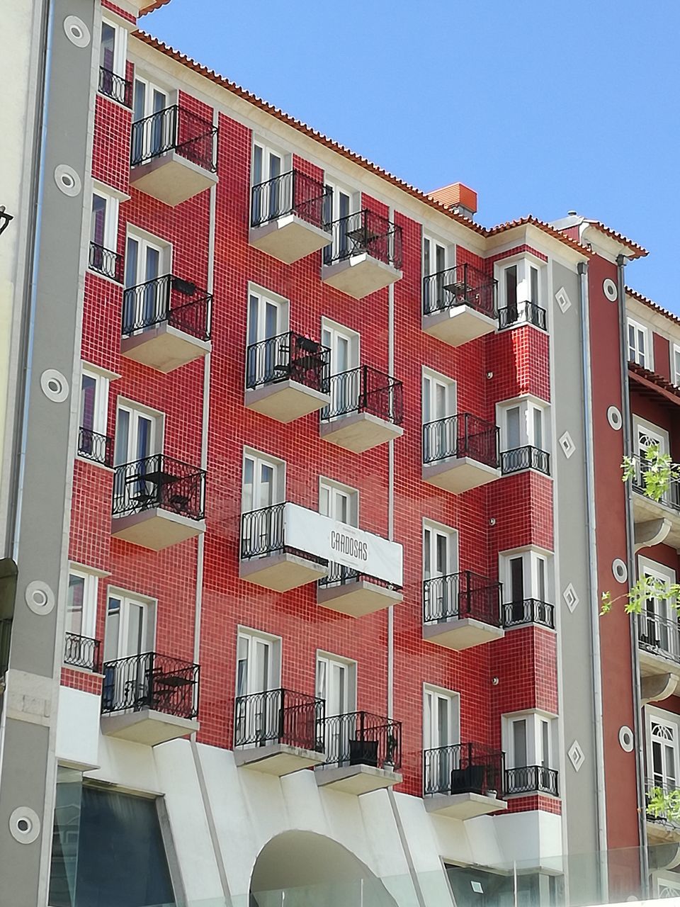 building exterior, architecture, red, built structure, low angle view, window, no people, residential building, day, clear sky, outdoors, apartment, city, sky