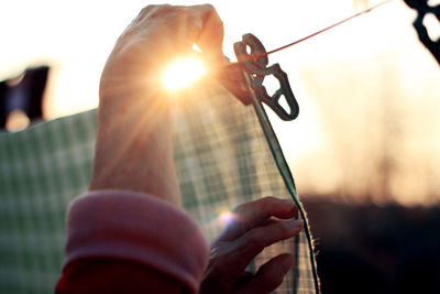 Close-up of hands hanging clothes on line