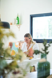 Female pottery artist making a vase in her home studio