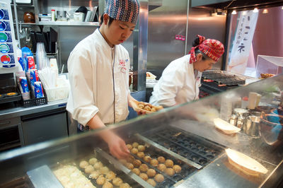 Midsection of man preparing food in store