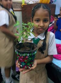 Portrait of smiling girl holding potted plant
