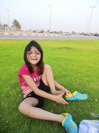 Portrait of a girl sitting on grassy field