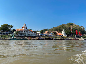 Buildings at waterfront against clear sky