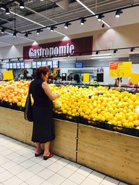Full length of woman with fruits in store