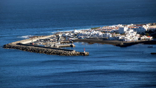 High angle view of sea and cityscape against sky