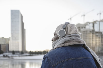 Mature man listening to music through headphones in winter