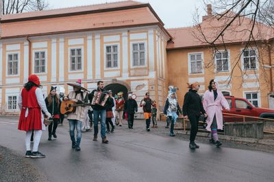 People on street against buildings in city