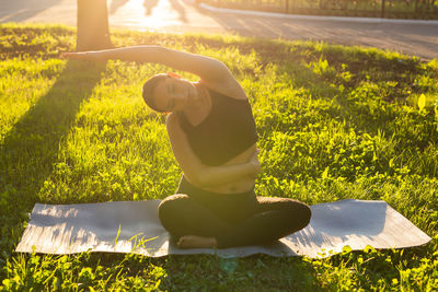 Rear view of woman sitting on field