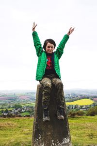 Portrait of happy man standing on field against sky