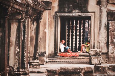 Man sitting outside old building