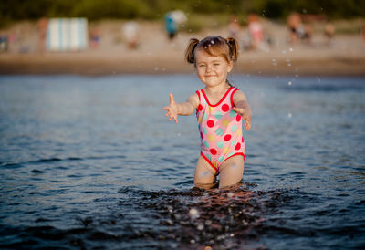 Cute girl playing in sea at beach