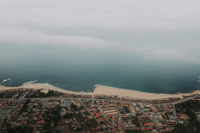 High angle view of townscape by sea against sky