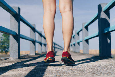 Low section of woman standing on bridge