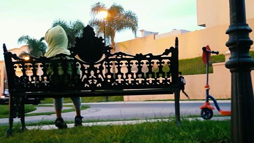 Statue by railing against sky