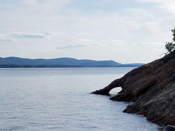 Scenic view of sea and mountains against sky