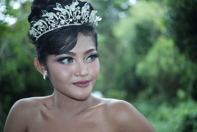 Beautiful young woman looking away while wearing tiara