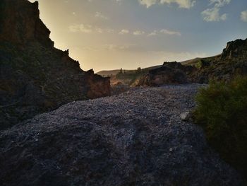 Rock formations on landscape against sky during sunset