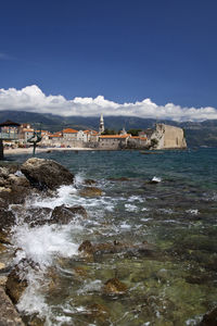 Scenic view of sea and buildings against sky