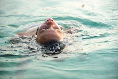 Portrait of young woman swimming in pool