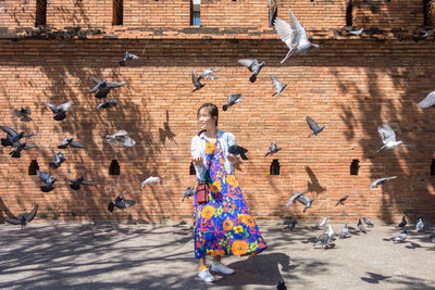 Full length of woman with pigeons