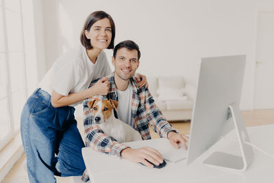 Happy friends sitting on laptop