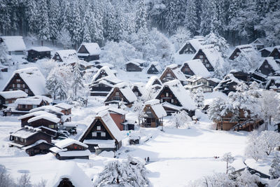 Snow covered houses by buildings