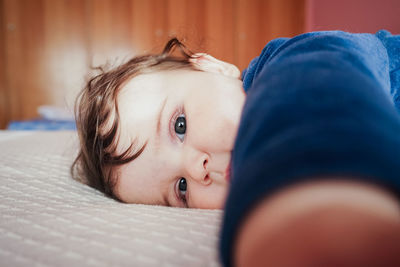 Portrait of cute baby girl on bed at home