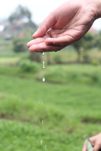 Close-up of hand holding water falling