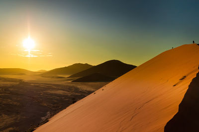 Scenic view of desert against sky during sunrise