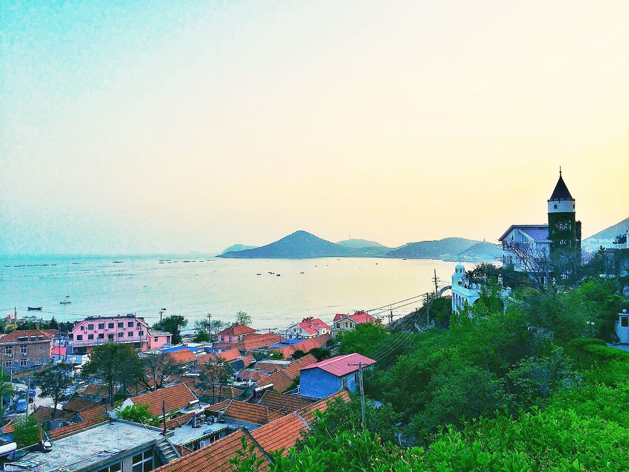 clear sky, sea, water, copy space, horizon over water, beach, built structure, scenics, tranquil scene, architecture, tranquility, beauty in nature, nature, shore, building exterior, tree, mountain, outdoors, idyllic, coastline