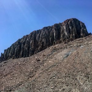 Low angle view of mountain against clear blue sky