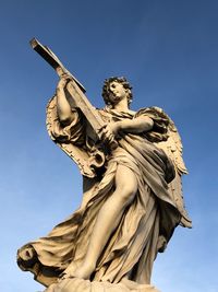 Low angle view of statue against blue sky