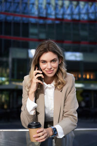 Portrait of young woman using mobile phone in cafe