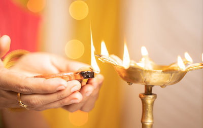 Close-up of woman holding burning candle