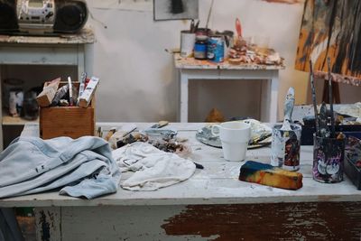 Messy painting equipment on table at workshop