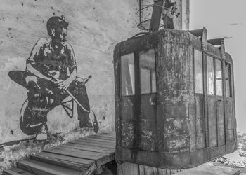 View of old man sitting on abandoned wall