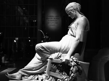 Side view of young woman sitting on chair