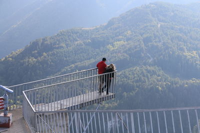 High angle view of friends standing at observation point against mountains