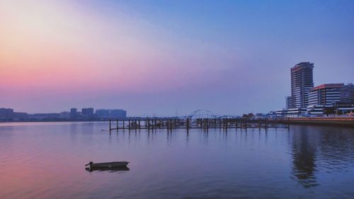 Boats in sea against clear sky during sunset