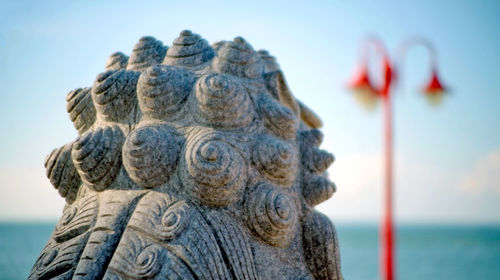 Close-up of statue against sea