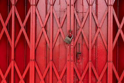 Close-up of padlock on red gate